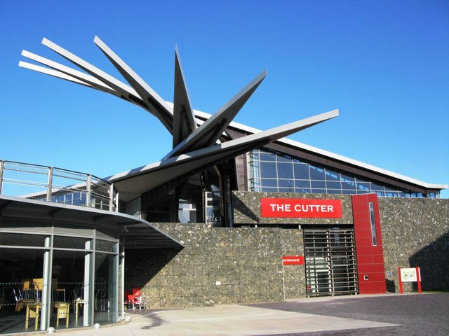 Stone-walled museum building with a red sign reading The Cutter and angular steel blades rising from its roof