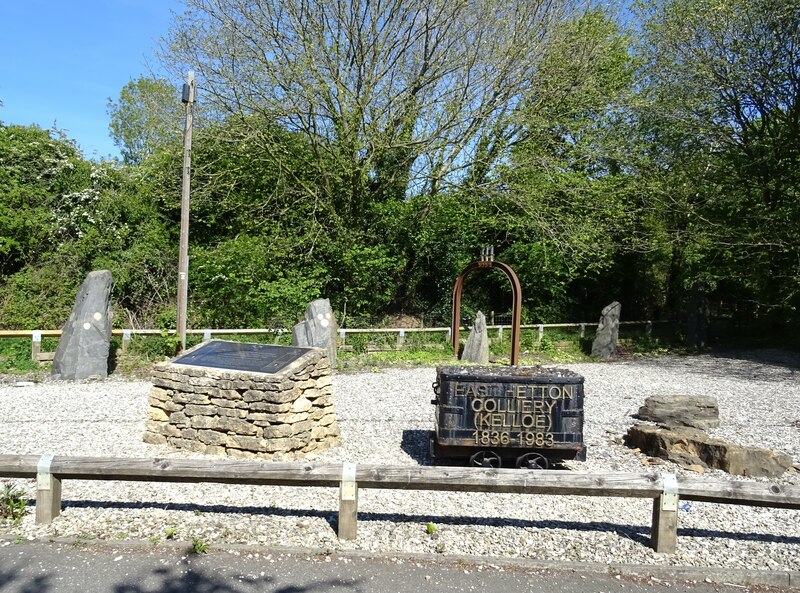 A colliery memorial with a coal tub lettered East Hetton Colliery (Kelloe) 1836-1983, a plaque and standing stones.