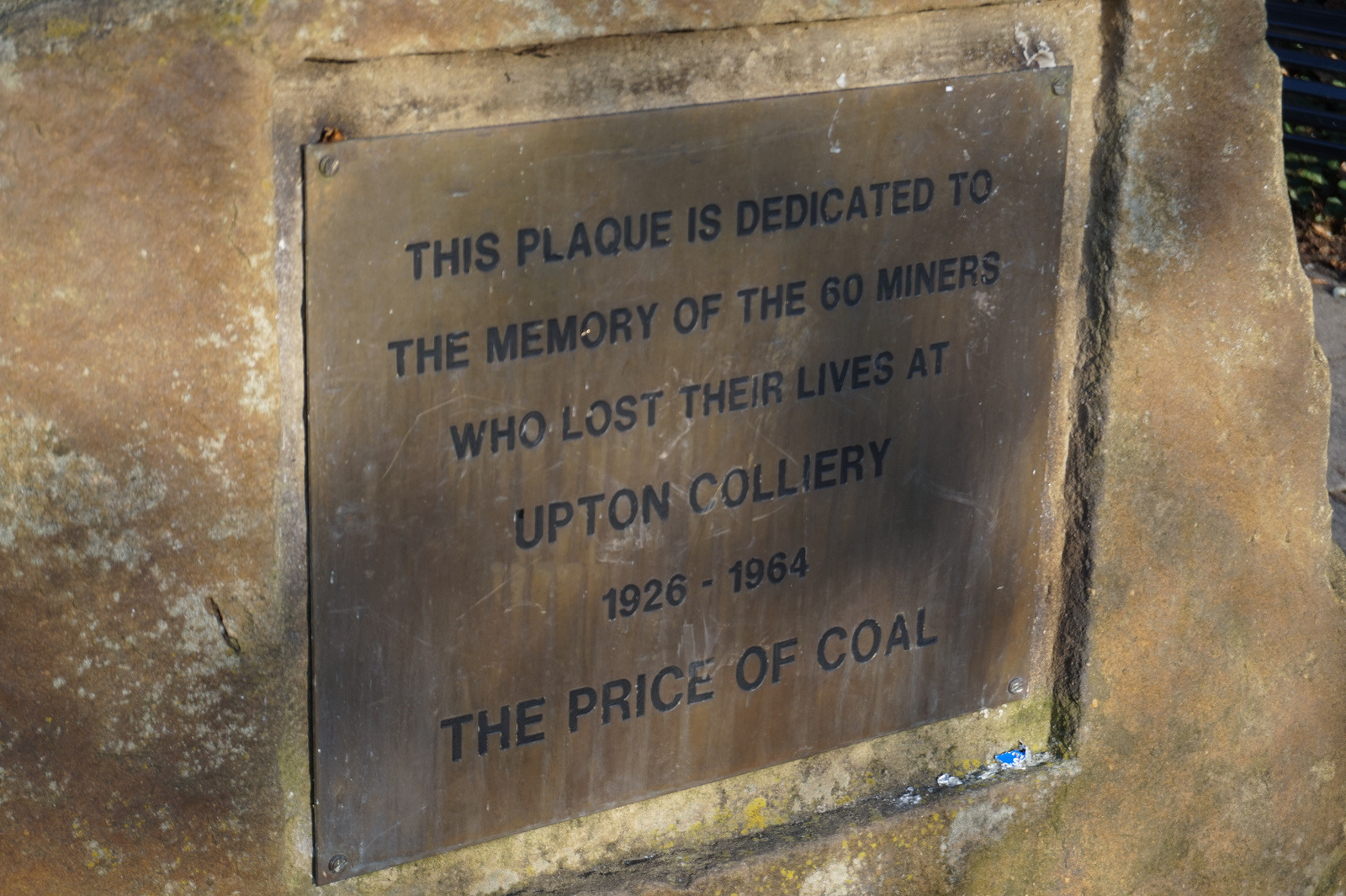 A stone memorial with an inscribed plaque in the memorial garden at Upton Country Park.
