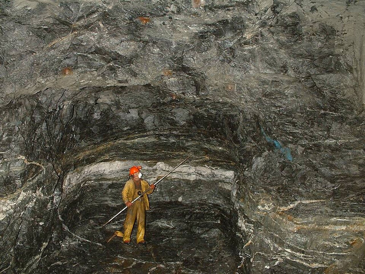 A quartz-gold vein exposed underground at the Nalunaq Gold Mine, Greenland, showing a well-defined sheet of mineralised quartz filling a fracture in the host rock — the typical shape of a vein deposit.