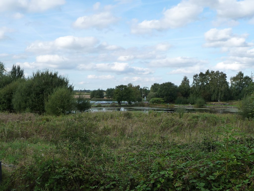 A calm, tree-lined body of open water at Marston, Cheshire — the subsidence lake that formed over the flooded Adelaide Mine workings after the 1928 collapse.