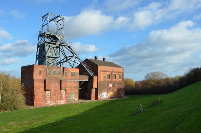 The steel headstocks and brick engine house of the colliery standing alone on cleared ground at Stairfoot