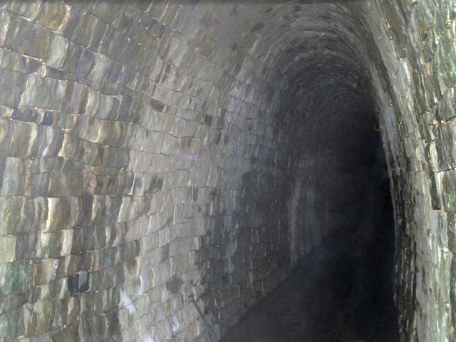 The stone arch of the level's portal beside the River East Allen, water still running out of it