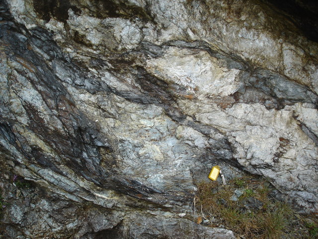 Exposed steatite bedrock at Catpund showing the soft grey soapstone and the carved hollows and tool marks left where Norse workers cut vessels out of the rock face