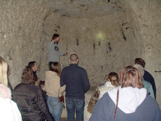 A wide chalk-cut passage in Chislehurst Caves, lit for visitors.