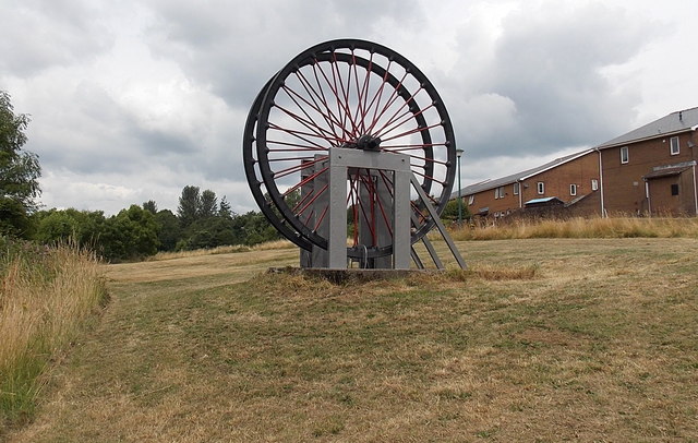 Two preserved colliery winding wheels standing beside houses at Southlands in Blaina.