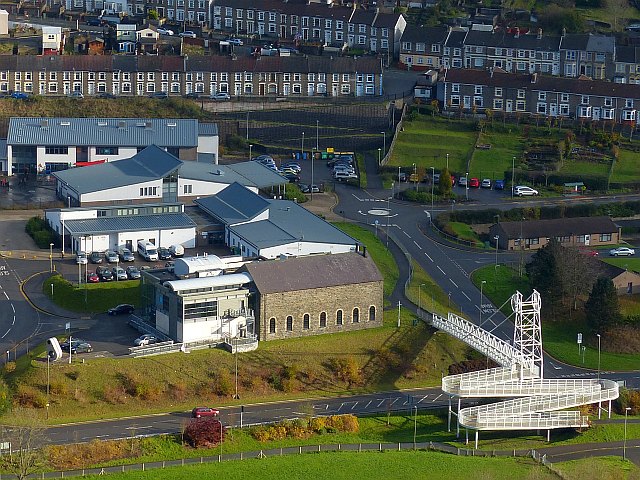 An aerial view looking down on the surviving East Pit winding house at Elliot Colliery, New Tredegar, now home to the Winding House museum, photographed from a nearby footbridge.