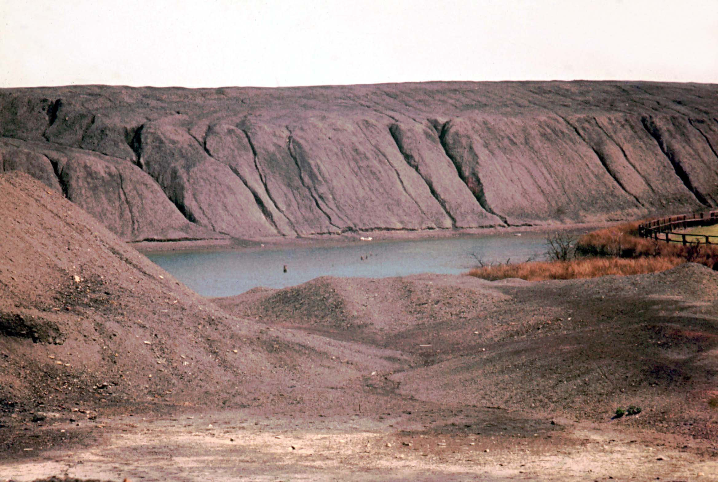 Spoil heaps riven with gullies and a flooded 'flash' between Higher Folds and Gin Pit village, photographed in June 1974; land reclamation has since transformed the site beyond recognition.