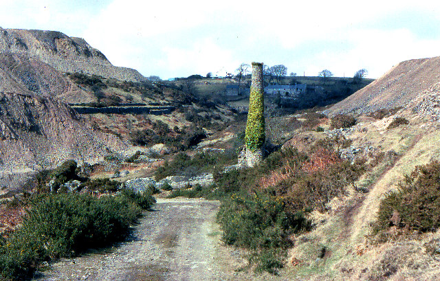 A ruined mine chimney standing amid extensive spoil tips on the hillside at Gonamena, Cornwall, photographed in 1979.