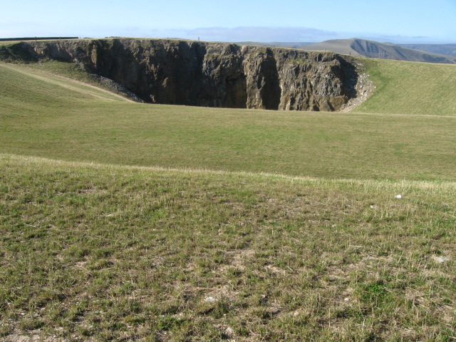 A broad stony track running along the line of a worked-out limestone rake on open moor.