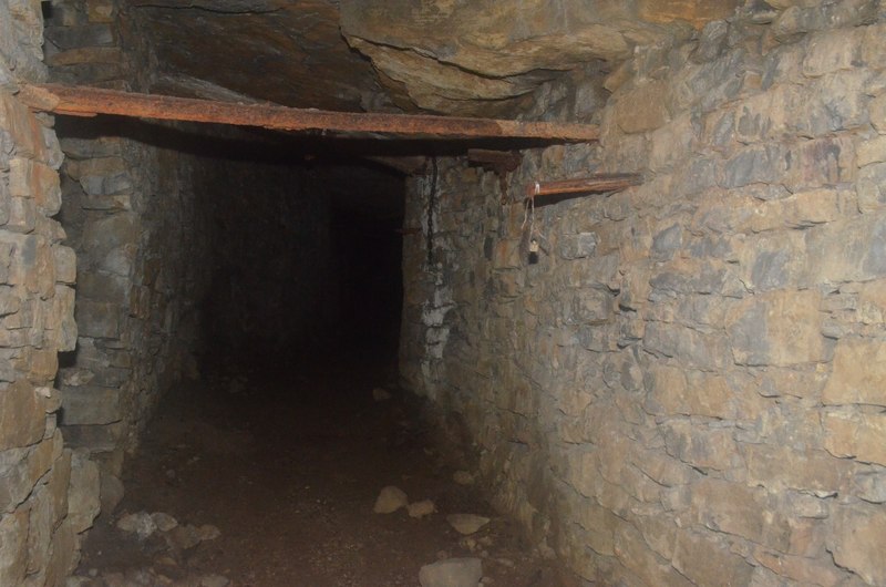 The disused quarry at Holme Bank, Bakewell, with an exposed rock face and the surviving buildings of the chert works.