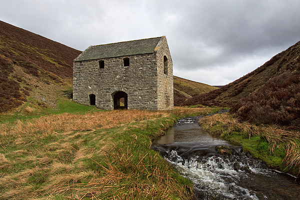 The surviving two-storey crushing mill of the Lecht manganese mine, standing alone on the open hillside near the Well of the Lecht.