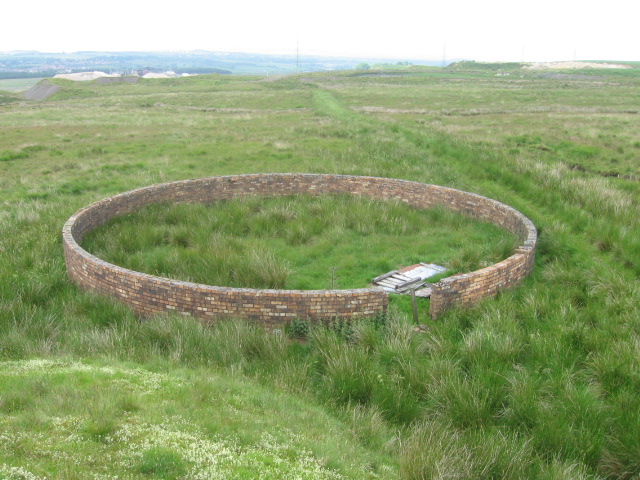 A circular brick sheepfold beside a grassy old mine track on the moor south of Fauldhouse.