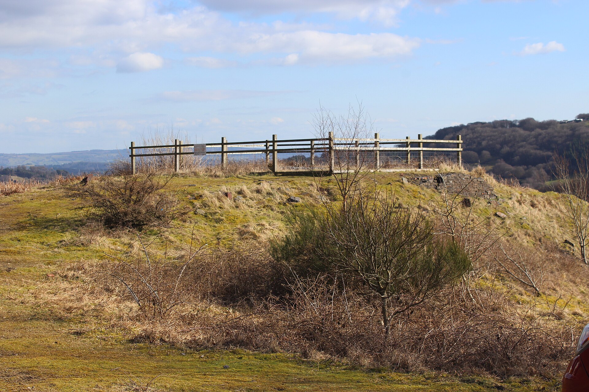 Fenced rough ground on the cleared site of Llanerch Colliery above Abersychan, with hillside behind.
