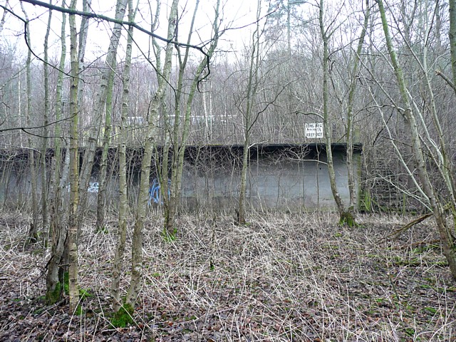 A large derelict concrete loading platform at the disused Long Meg gypsum and anhydrite mine, weathered and overgrown at its edges