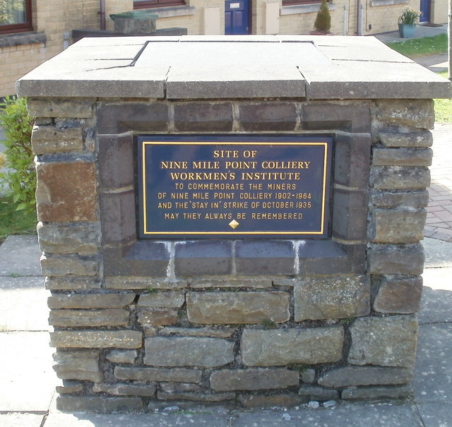 A commemorative plaque set into a low wall or plinth, recording the site of the former Nine Mile Point Colliery Workmen's Institute at Cwmfelinfach.