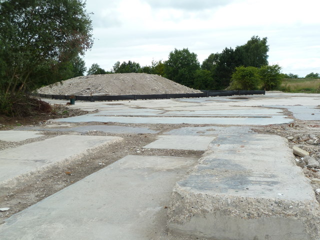 Broken concrete slabs of the cleared North Selby pithead area in 2013, with a mound of rubble and trees behind