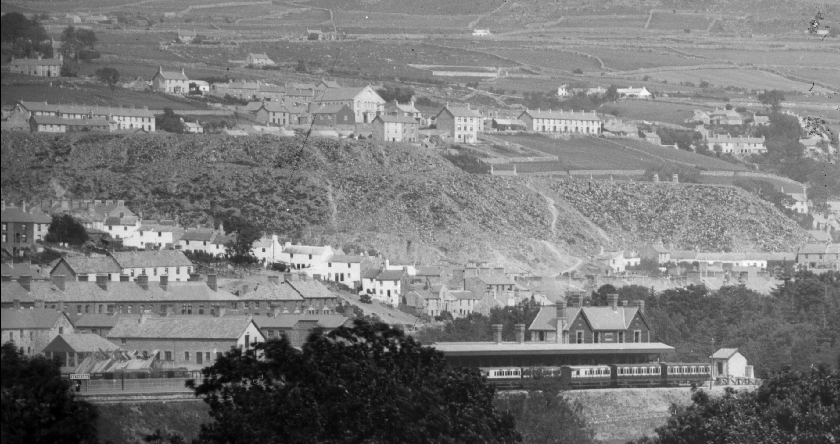 Bethesda railway station in 1885, with the waste tips of Pantdreiniog quarry visible behind.