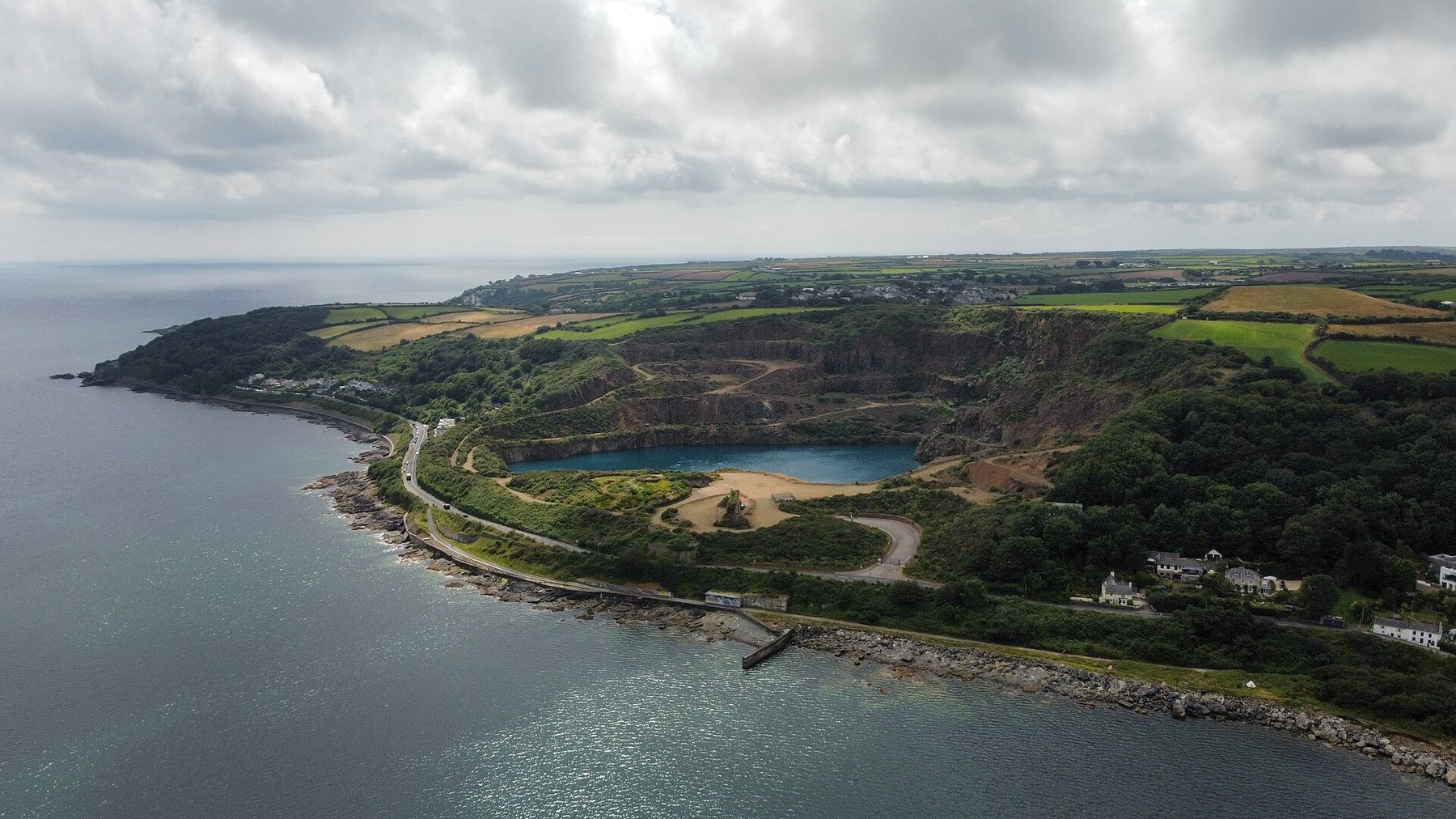 The worked benches and faces of Penlee Quarry on the hillside above Newlyn in west Cornwall, with Mount's Bay beyond