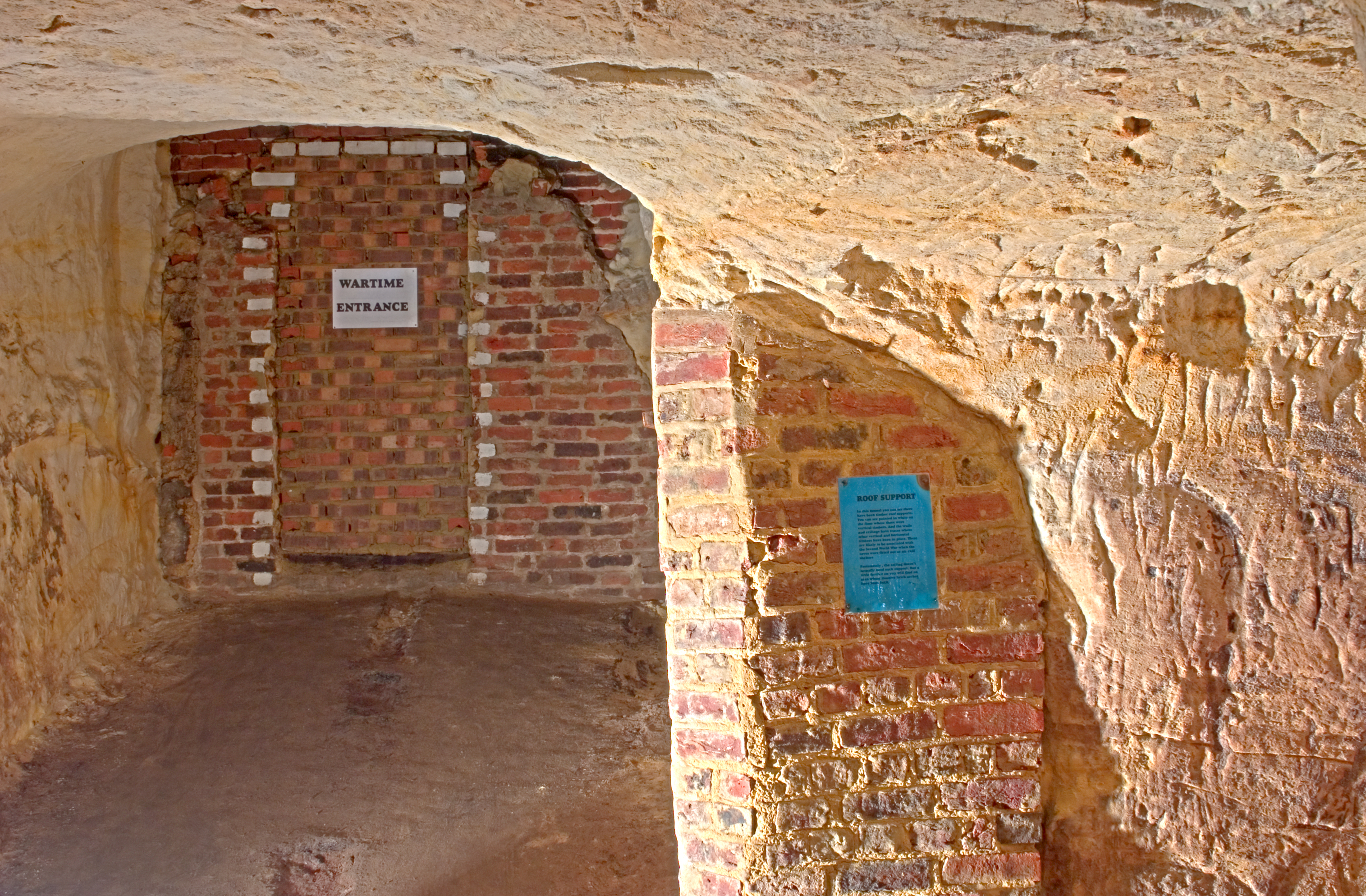 A brick and stone doorway in the wall of the Reigate road tunnel, used as an air-raid shelter entrance during the Second World War.
