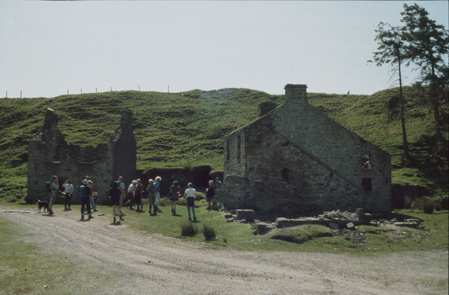 The stone-arched portal of the Blackburn Level driven into the fellside, with ruined stone buildings standing to either side of the entrance