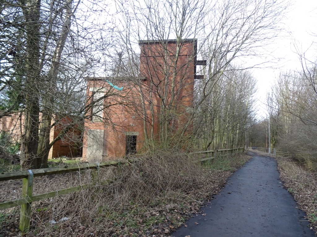 Low brick colliery buildings still standing on the former Seaton Delaval Colliery site, surrounded by rough grass.