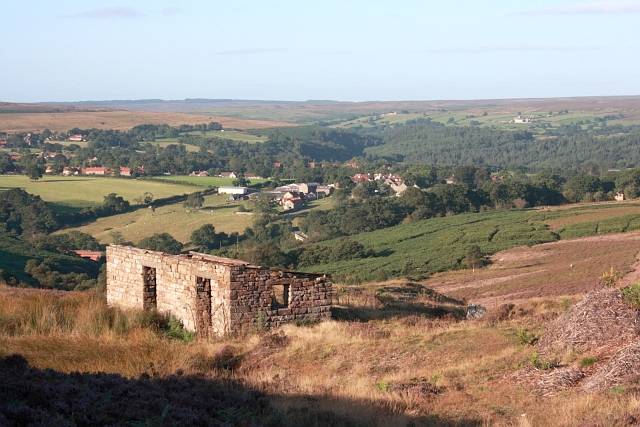 The stone-lined mouth of the Sil Howe drift in rough moorland, with the ruins of the mine building beside it.