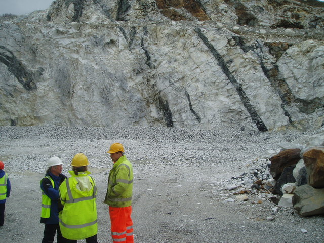 The quarry face at Torrin, showing white marble cut through by dark basaltic dykes.