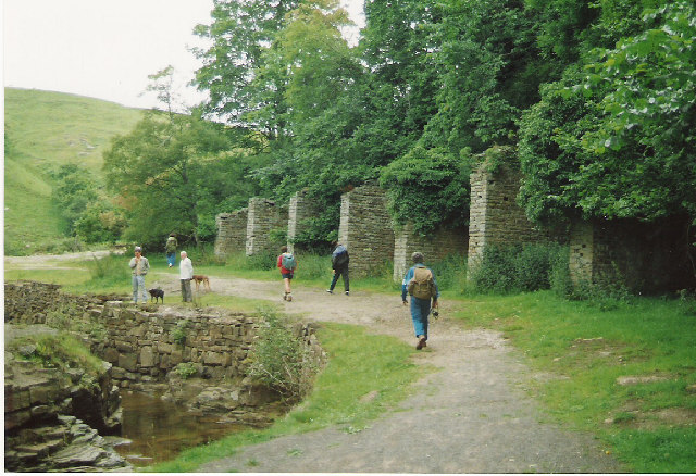 The mine's surviving bouse teams: stone-walled ore-storage bins with an overhead tramway, photographed among Weardale moorland.