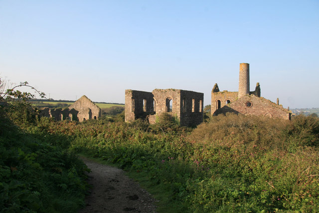 The derelict remains of the Marriott's Shaft complex at South Wheal Frances, including engine house buildings and a chimney stack, in open Cornish countryside.