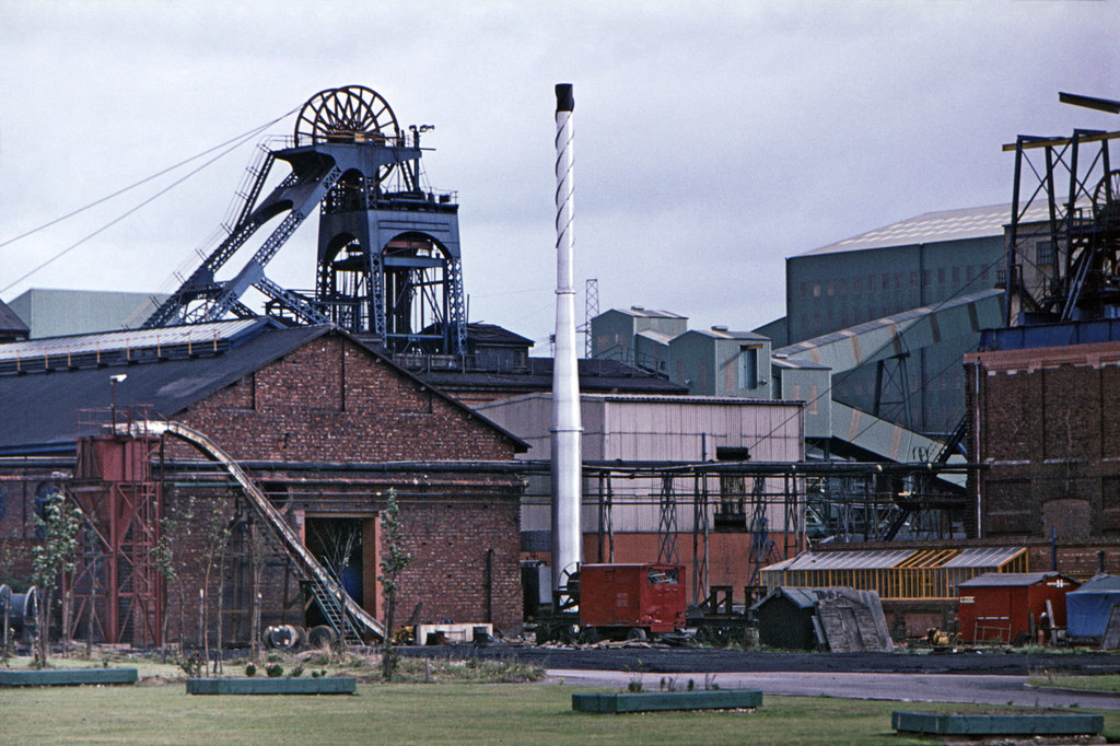 The colliery in 1977: headgear and pithead buildings above the village, with railway sidings in front.