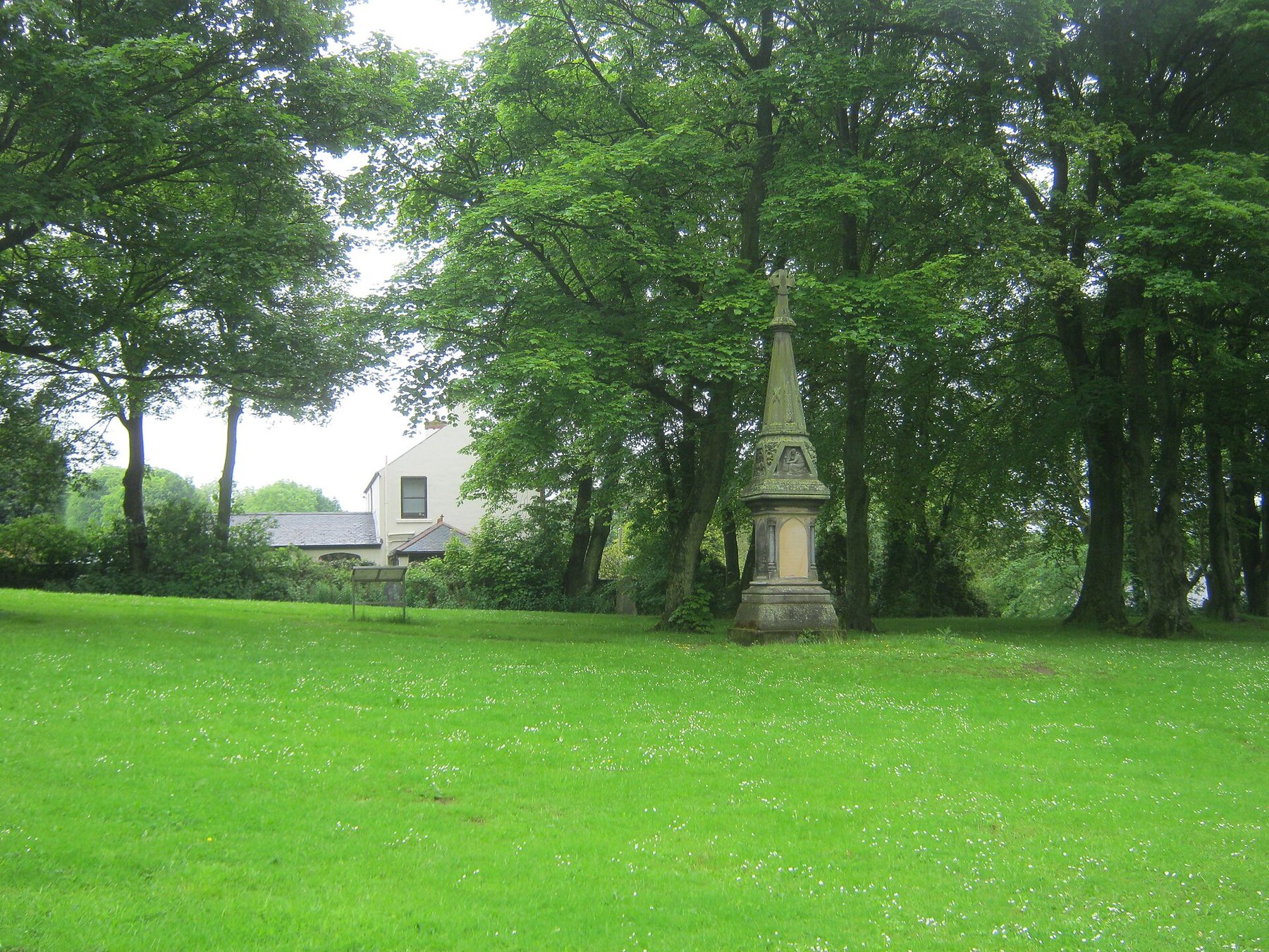 Gothic Revival sandstone memorial cross beside St Helen's Church at Kelloe, County Durham, raised by fellow workmen to the 74 men and boys killed in the 1882 Trimdon Grange explosion