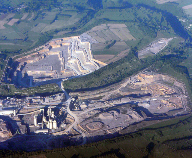 An aerial view of Tunstead limestone quarry and cement works, with the narrow strip of Great Rocks Dale running through the centre and separating the two main areas of working