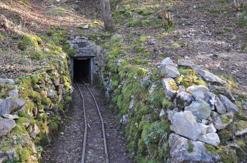 A small stone-arched mine adit entrance with an old tramway leading into it, on the hillside near Middleton, Derbyshire