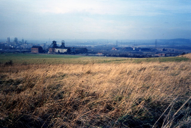 Wheldale Colliery's winding gear and surface buildings seen across open fields, with the Hickson & Welsh chemical plant visible to the left, photographed in 1989.
