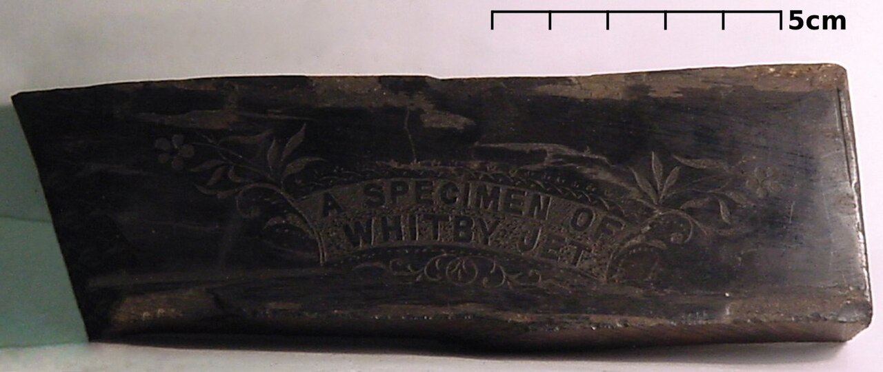 A specimen of Whitby jet, collected around 1895, shown here with a US quarter for scale.