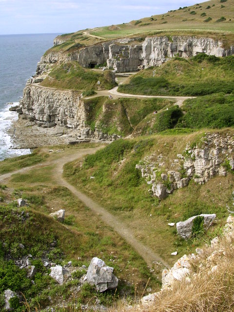 The disused Winspit Quarry on the Isle of Purbeck coast, showing galleries cut into the cliff face on both sides of the valley.