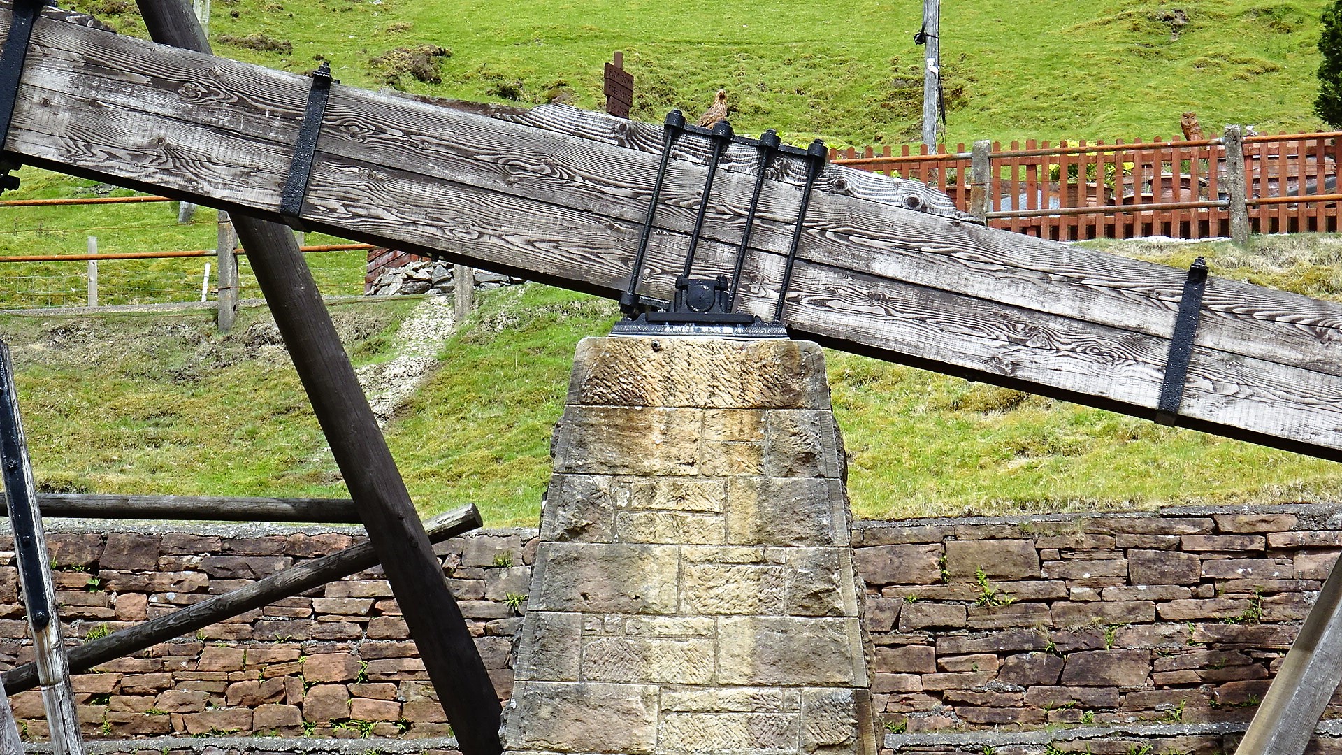 Close detail of a beam engine's massive timber beam pivoting on its stone bearing block, at Wanlockhead, Scotland — the only original water-powered beam engine surviving in the UK.