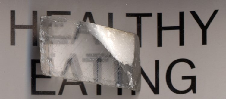 A calcite crystal specimen demonstrating the mineral's characteristic double refraction of light.