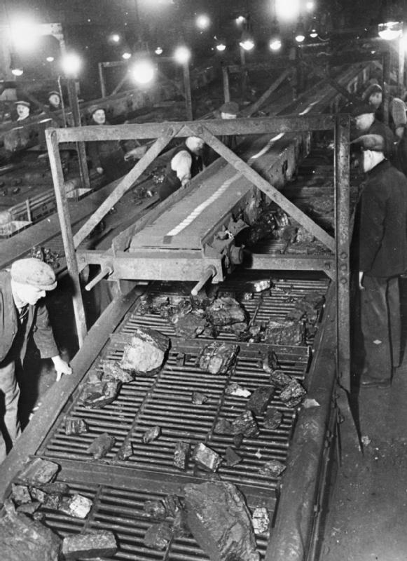Miners screening coal for quality as it reaches the surface by conveyor belt at a colliery somewhere in Britain, 1942 — a wartime Ministry of Information photograph.