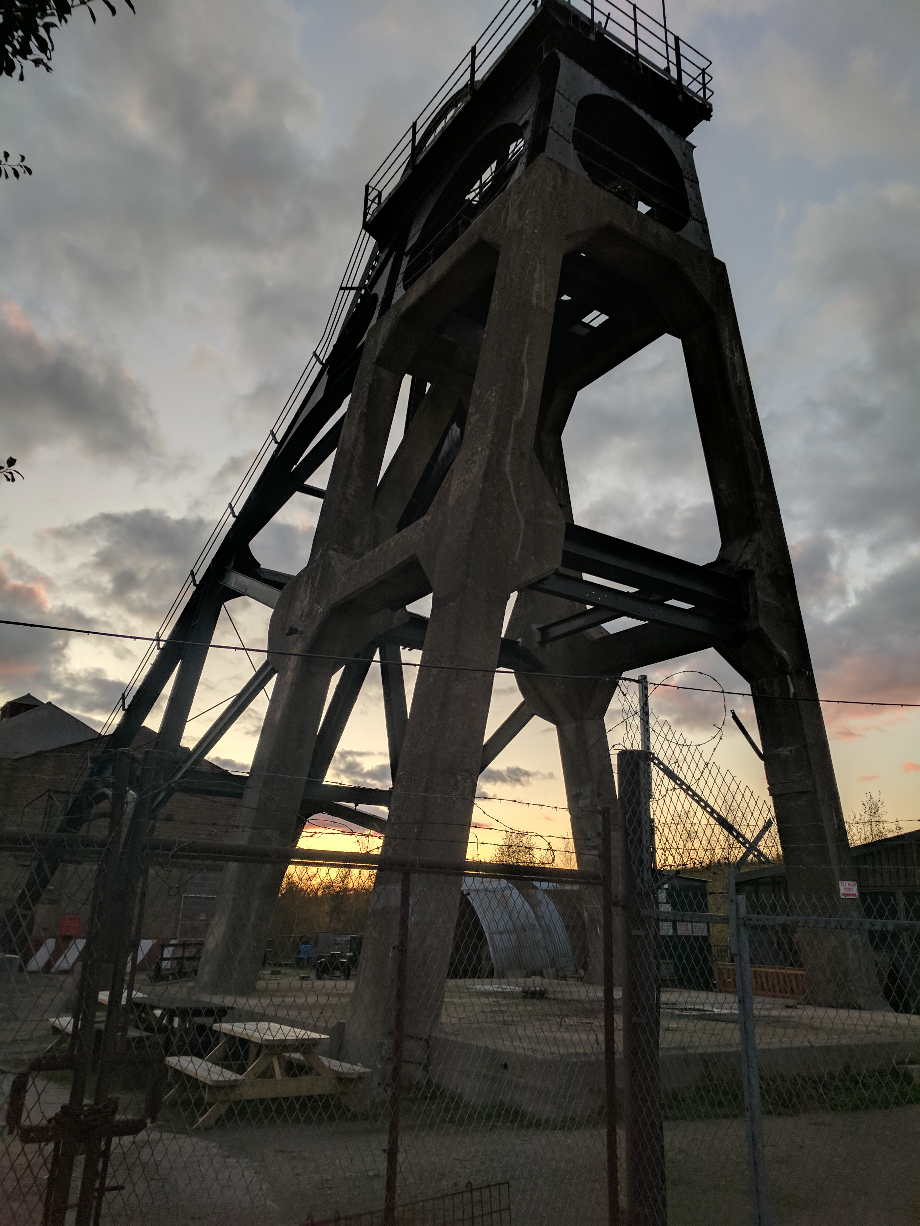 The surviving surface group at Pleasley Colliery, Derbyshire — headstocks over the shaft, the winding engine house beside them and the boiler-house chimney behind.