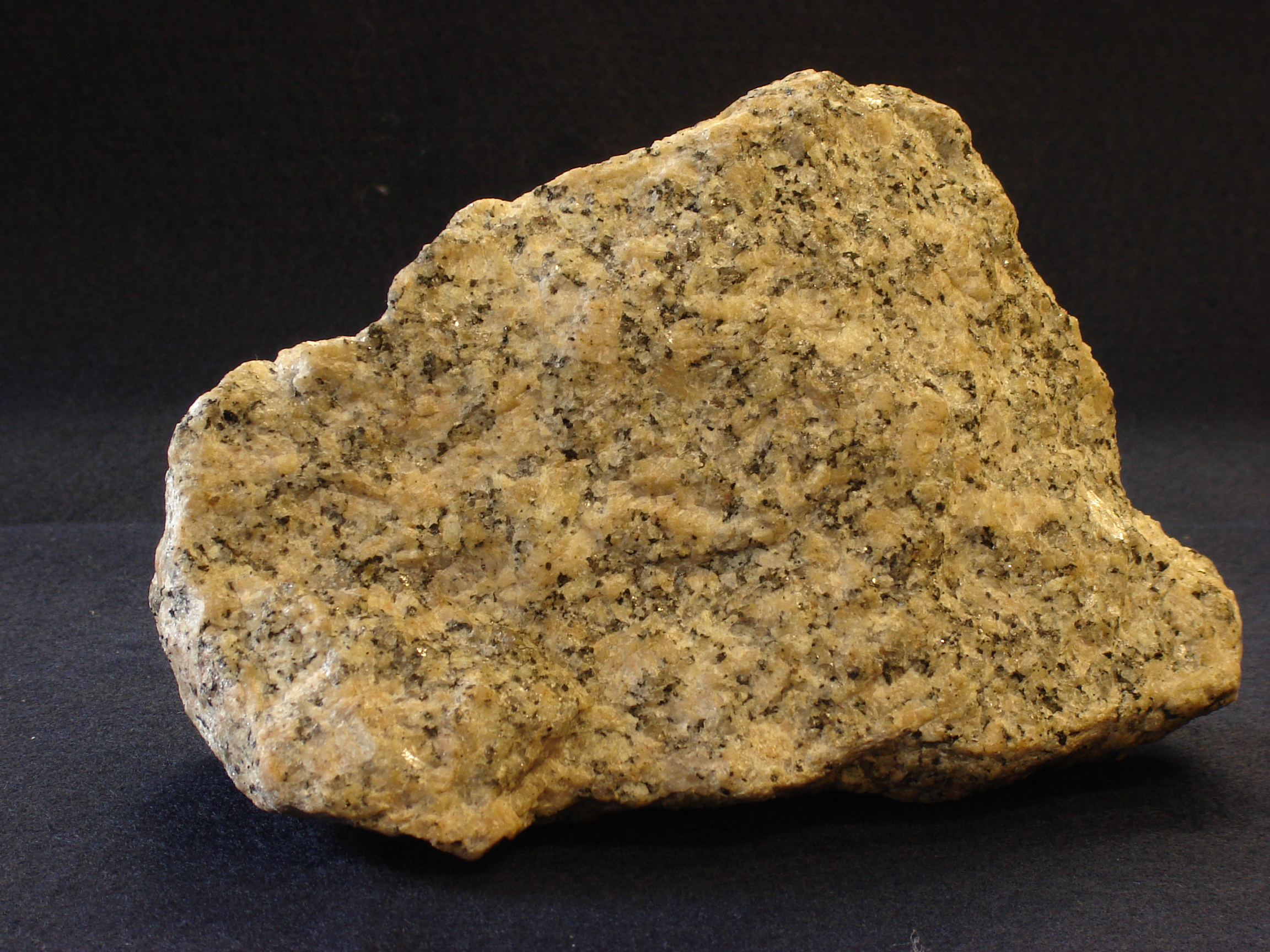 A hand specimen of granite showing its characteristic coarse-grained texture and pale feldspar crystals.