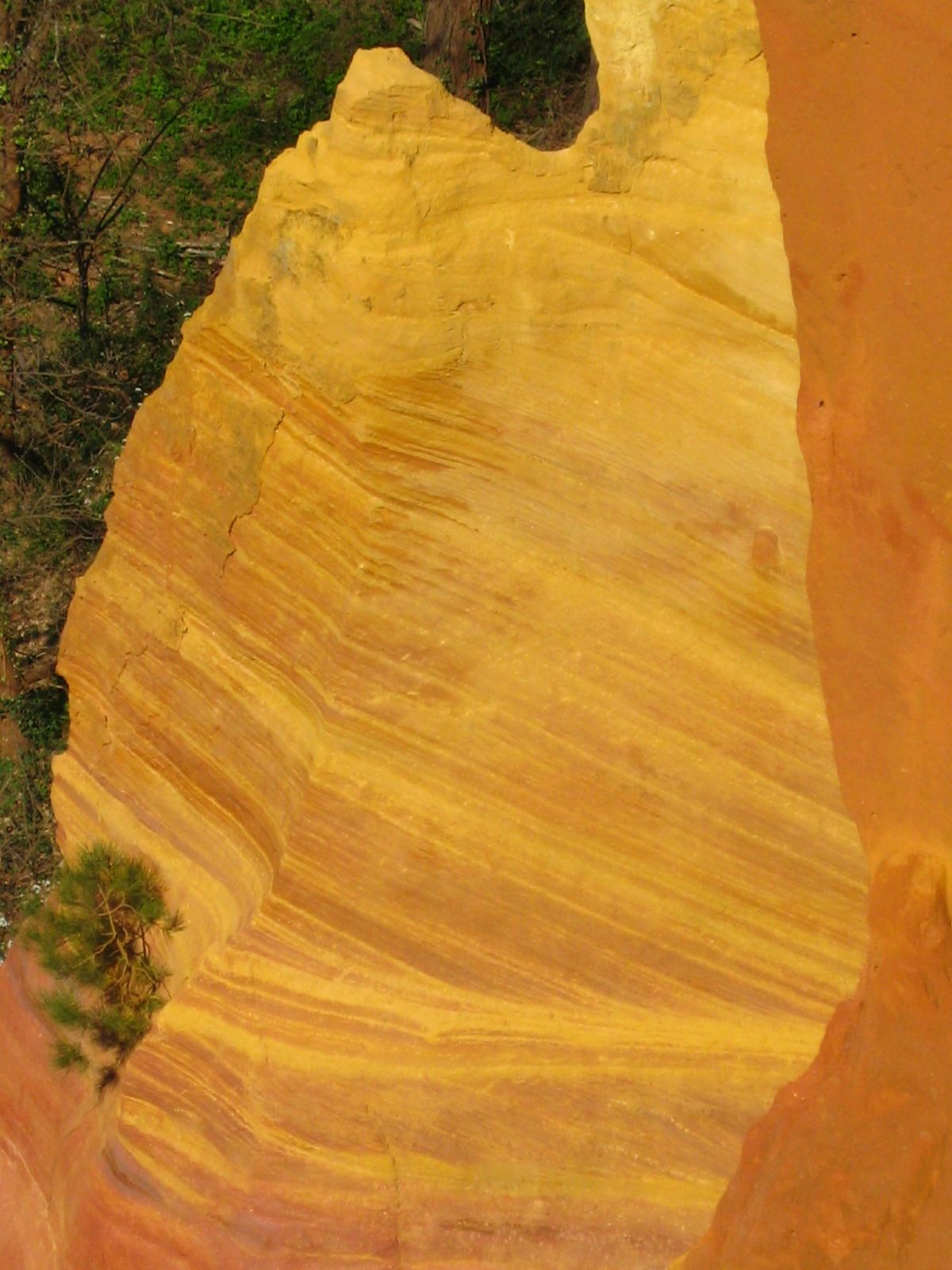 An ochre quarry face showing the characteristic banded yellow and red iron-oxide earth from which ochre pigment is dug.