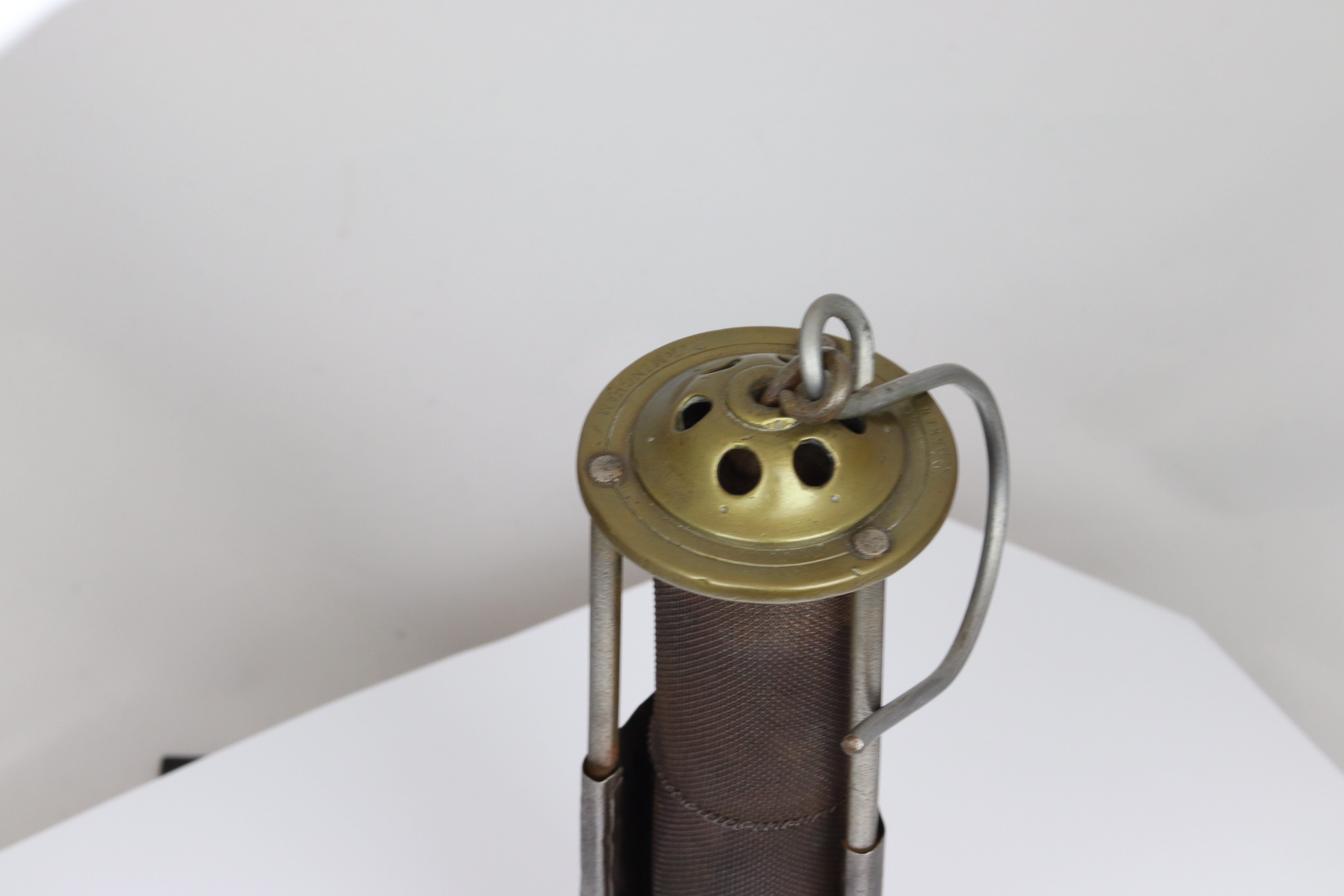 A Davy safety lamp, its flame enclosed in fine metal gauze to prevent it igniting firedamp.