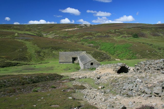 The surviving smelt mill building at Grinton, with its flue running up the hillside behind.