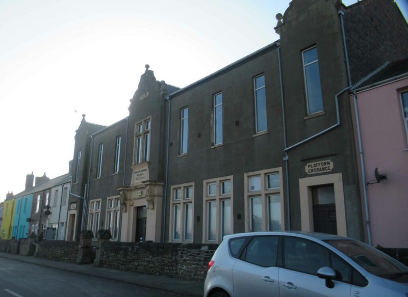 A long single-storey brick institute building with a pitched roof standing on a village street.