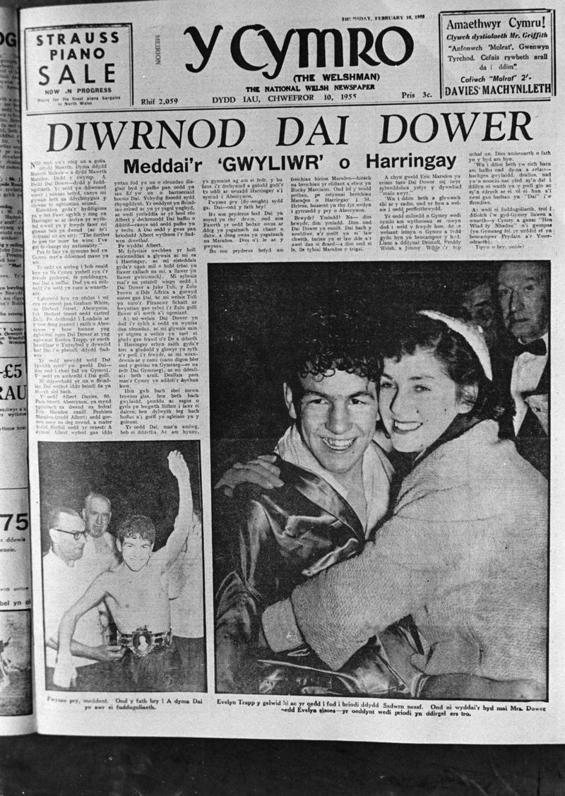 A 1955 Welsh newspaper front page with the headline Diwrnod Dai Dower, a photograph of the boxer embraced by a young woman and a smaller one of him wearing a championship belt.