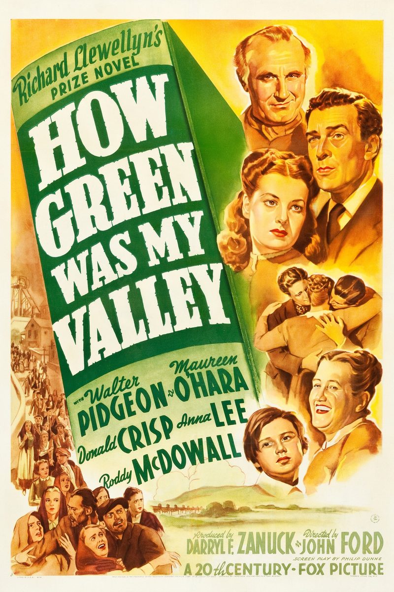 Film poster with the title in white on a green banner, painted faces of the cast, and a pithead and crowd of villagers at the left edge.