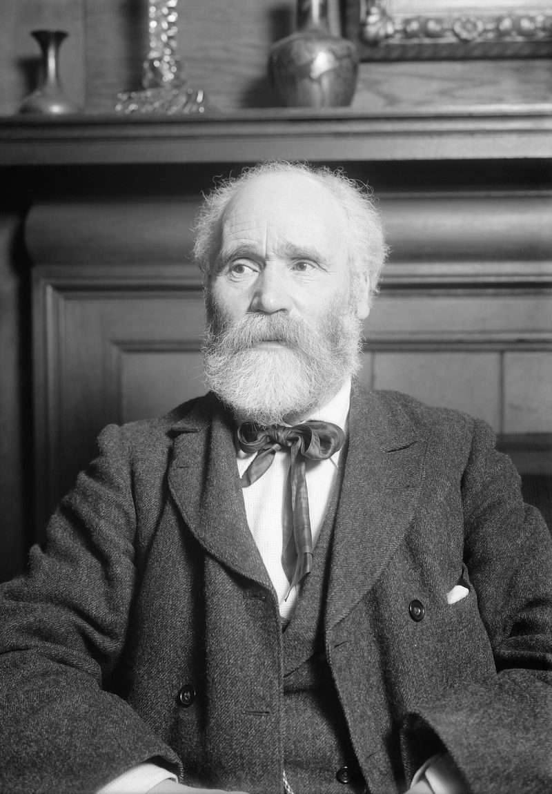 Black and white head-and-shoulders portrait of Keir Hardie, bearded and grey-haired, in a dark jacket.