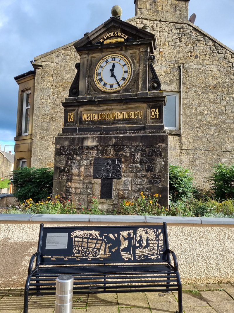 A bronze relief of shale miners carrying an injured man, above a tablet naming the fifteen men who died at Burngrange.